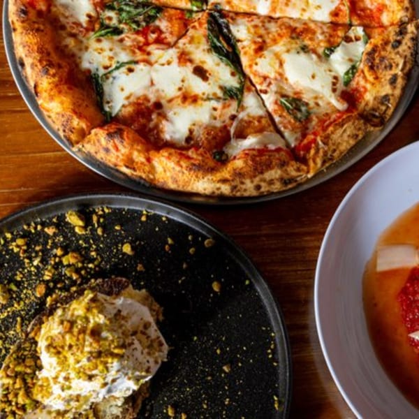 A Pie95 Pizza with basil and mozzarella, a dessert with pistachios, and a bowl of soup.
